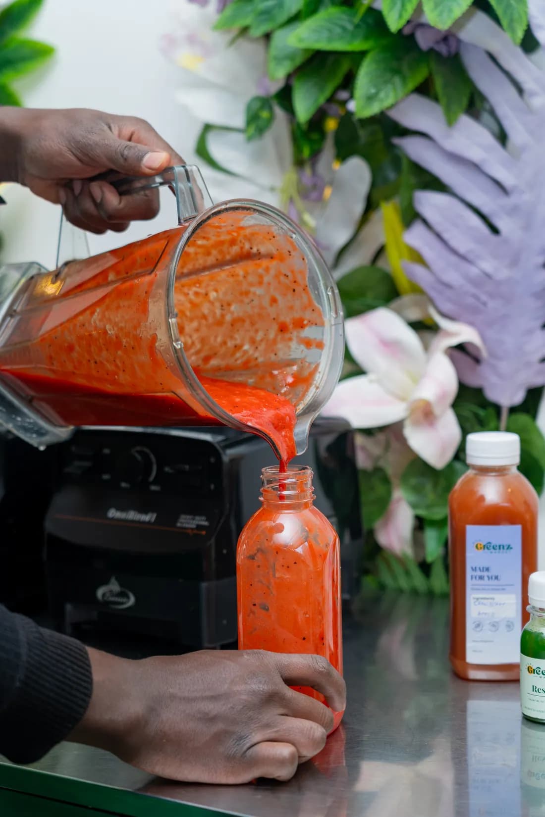 A cold-pressed blend being poured into a Local Greenz bottle at the in-store juice bar